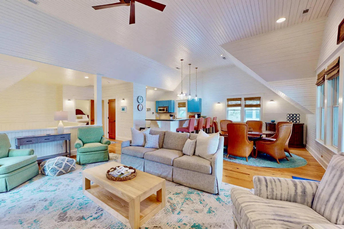 A cozy interior featuring a sofa, coffee table, and armchairs all arranged around a dining area. The layout supports social activities like family gatherings or relaxing afternoons, with a warm, inviting mood created by thoughtful furniture placement and lighting.